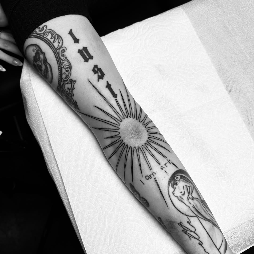 Striking elbow tattoo blending lust and sun motifs Tattoo Design