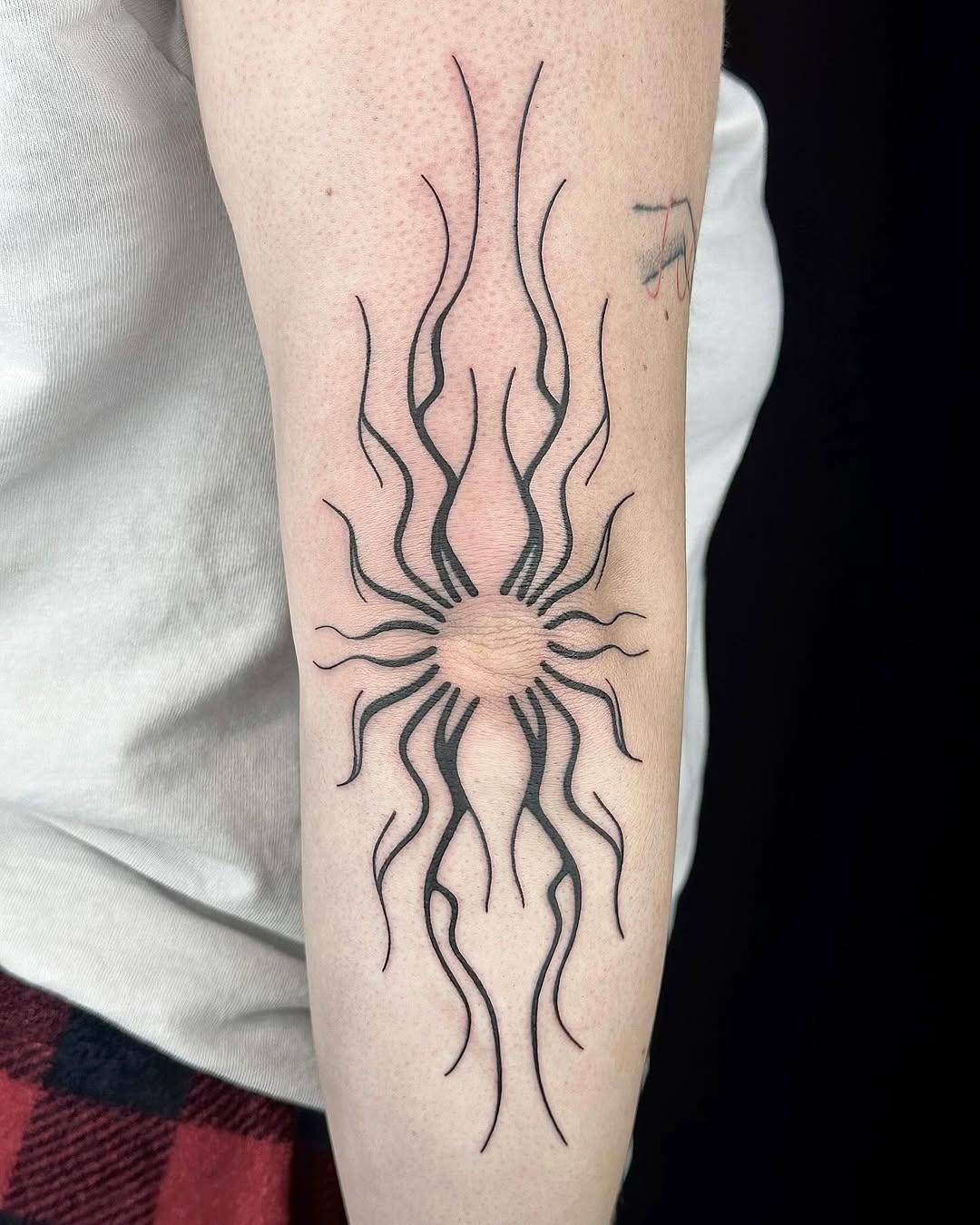 Stylish sunburst elbow tattoo with sharp lines Tattoo Design