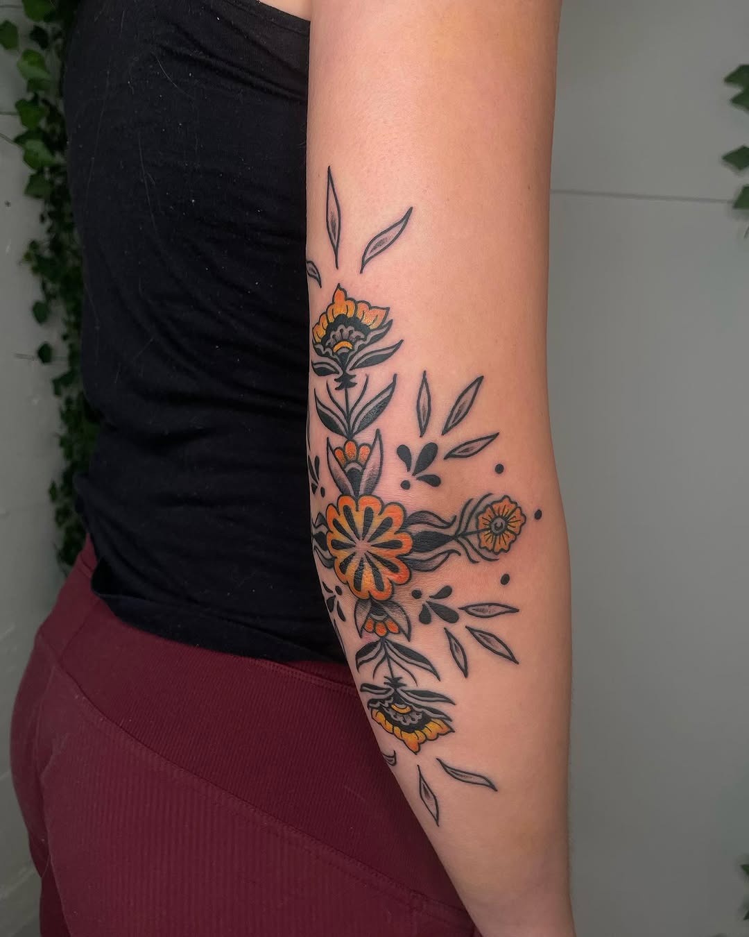 Vibrant floral elbow tattoo with bold outlines Tattoo Design