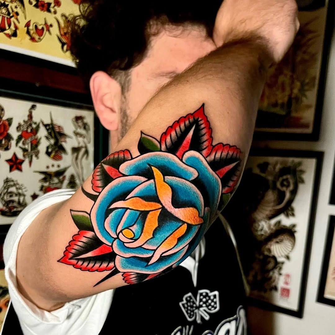 Vibrant rose elbow tattoo with colorful accents Tattoo Design