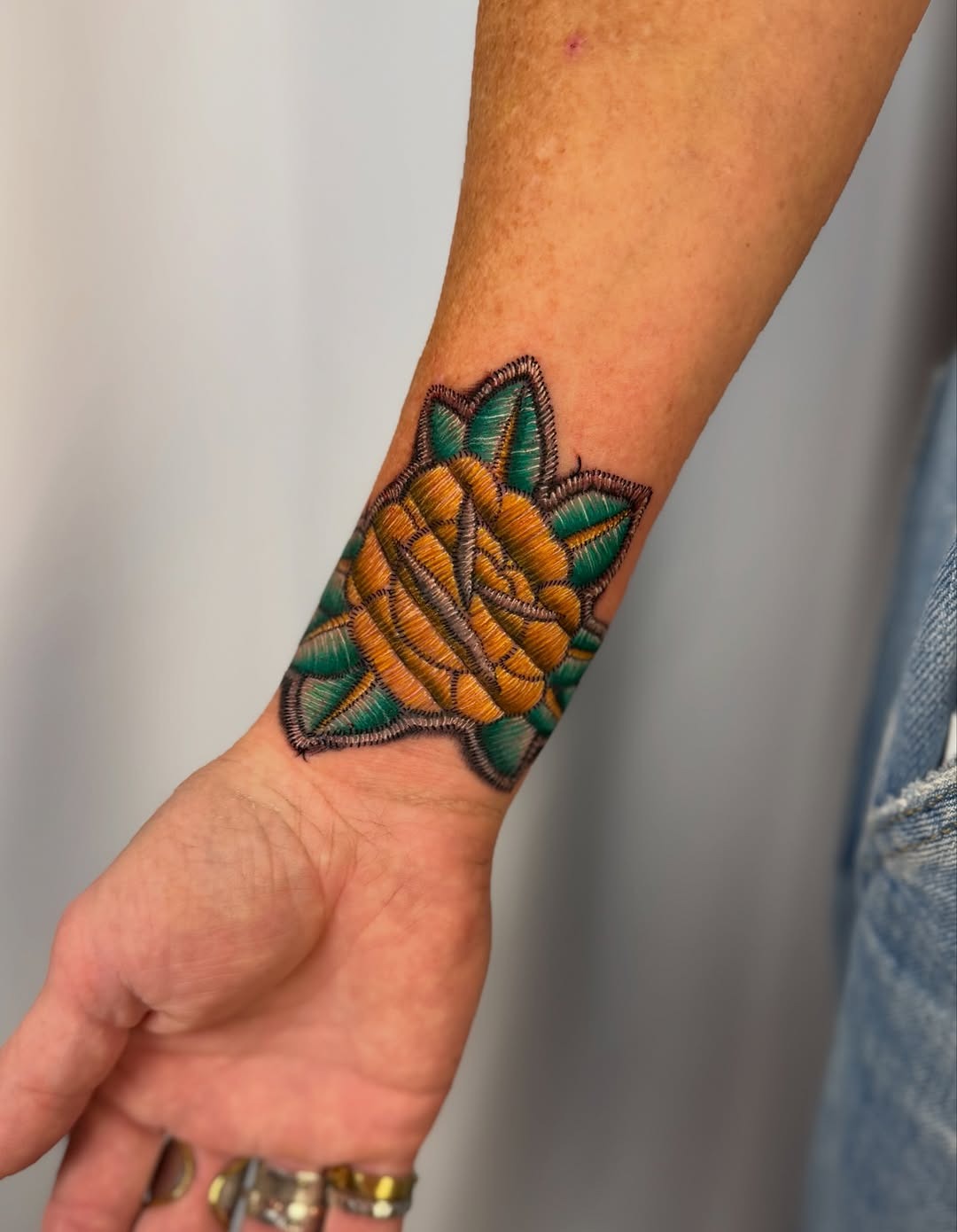 Stunning embroidery-style flower tattoo on wrist Tattoo Design