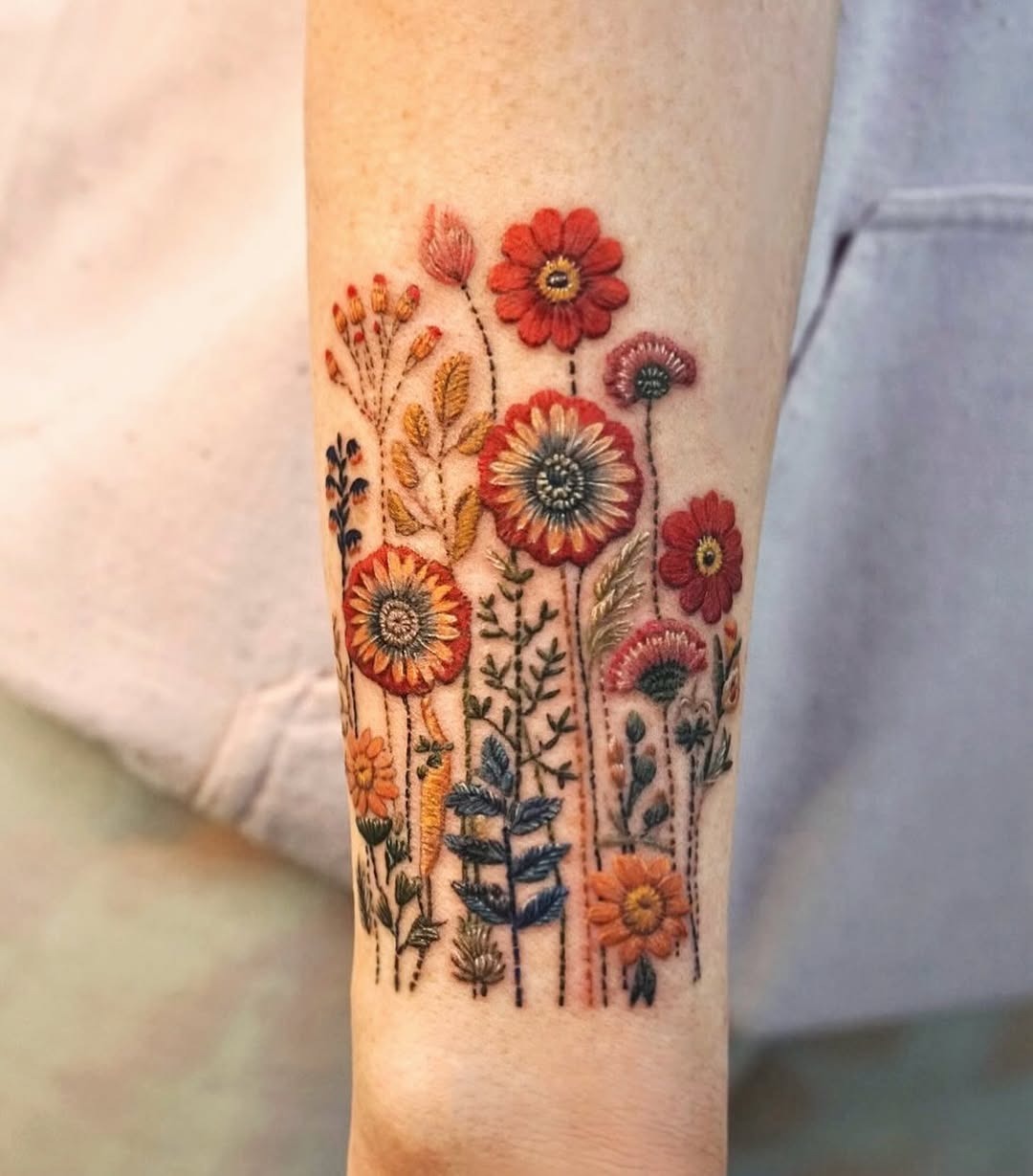Vibrant floral embroidery tattoo on the arm Tattoo Design