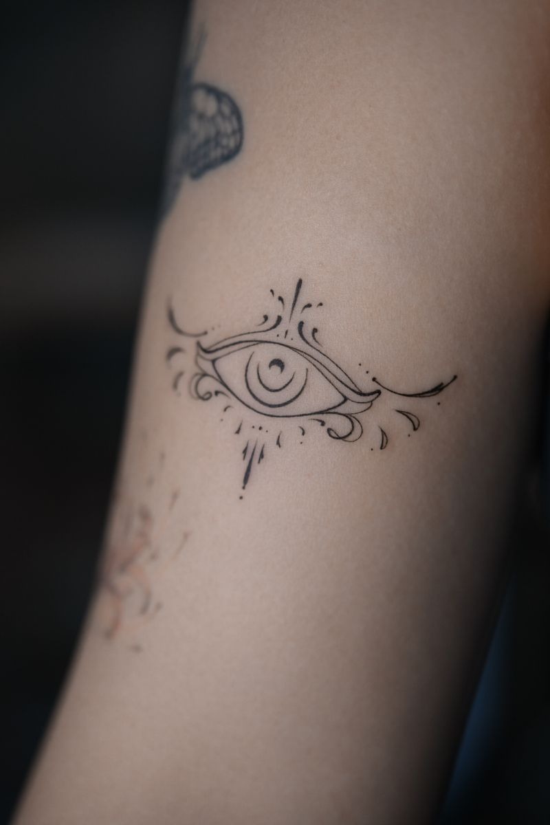 Soft Fine Line Evil Eye With Curved Flourishes Tattoo Design