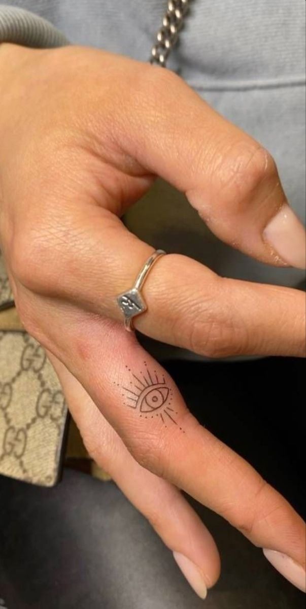 Tiny Finger Evil Eye With Sunburst Lines Tattoo Design