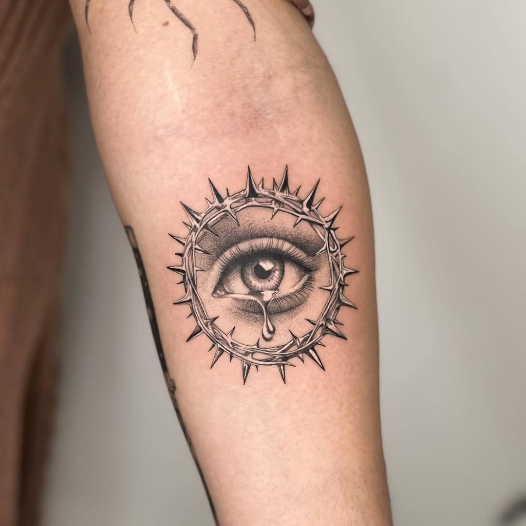 Intricate eye tattoo with thorny crown design Tattoo Design