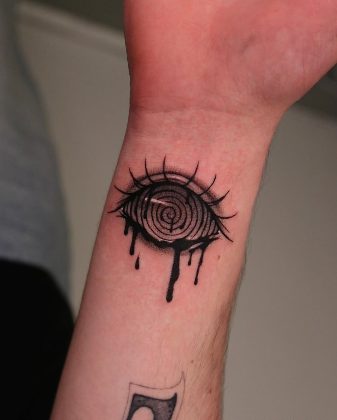 Striking spiral eye tattoo with dripping detail Tattoo Design