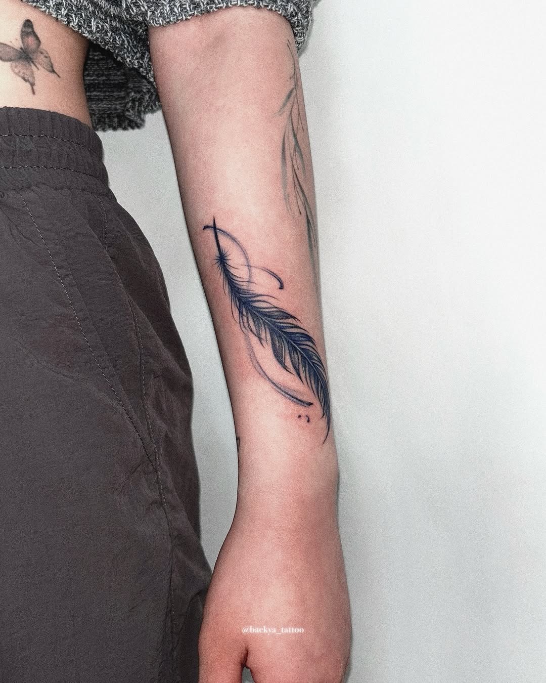 A striking feather tattoo on the forearm Tattoo Design
