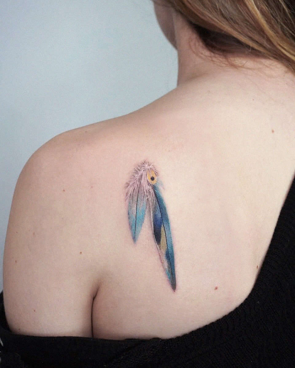 Elegantly vibrant feather tattoo on the shoulder. Tattoo Design