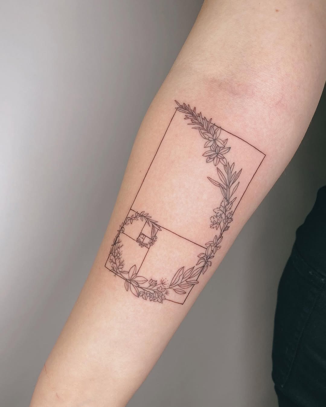 Elegant Fibonacci Spiral with Floral Accents Tattoo Design