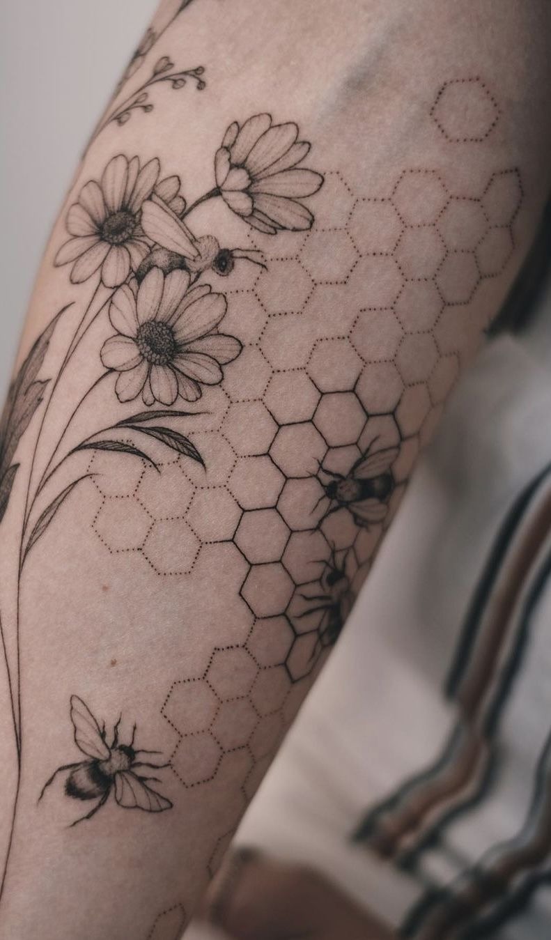 Delicate Honeycomb with Bees and Daisies, a tattoo design rendered in bold.