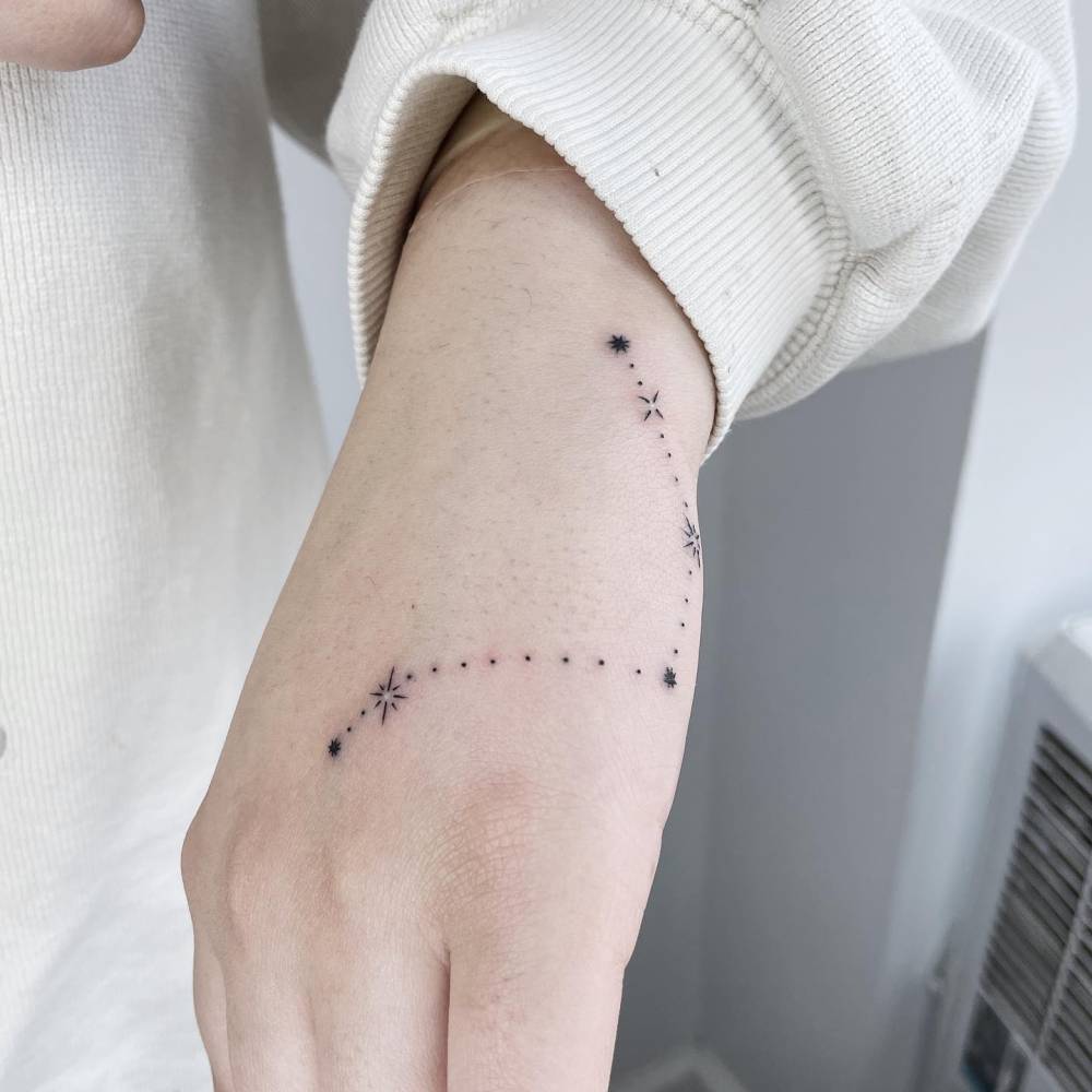 Tiny constellation of dots and hairline connectors tattoo on the wrist