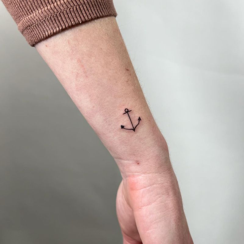 Minimal fine line anchor tattoo on the wrist
