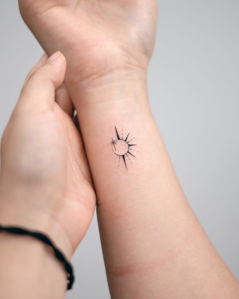 Fine line sunburst tattoo on the inner wrist