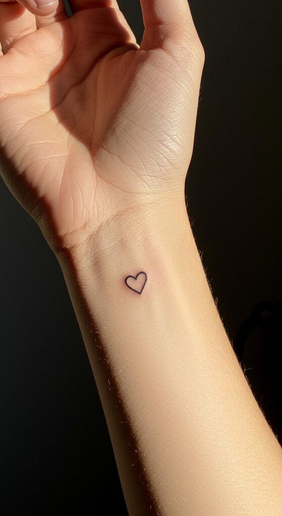 Tiny fine line heart tattoo on the inner wrist