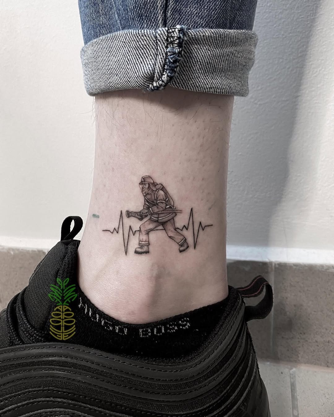 This tattoo showcases a firefighter in action, skillfully combined with a heartbeat line.