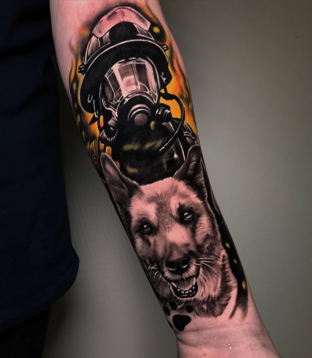 This captivating tattoo showcases a firefighter's helmet nestled against a loyal dog's face, embodying the bond between first responders and their canine partners.