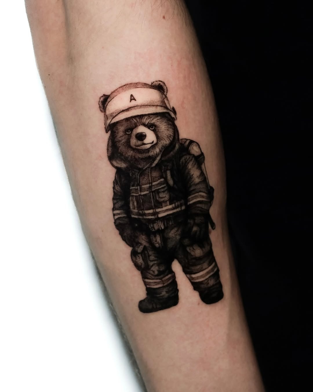 This tattoo features an adorable bear wearing firefighter gear, complete with a helmet.