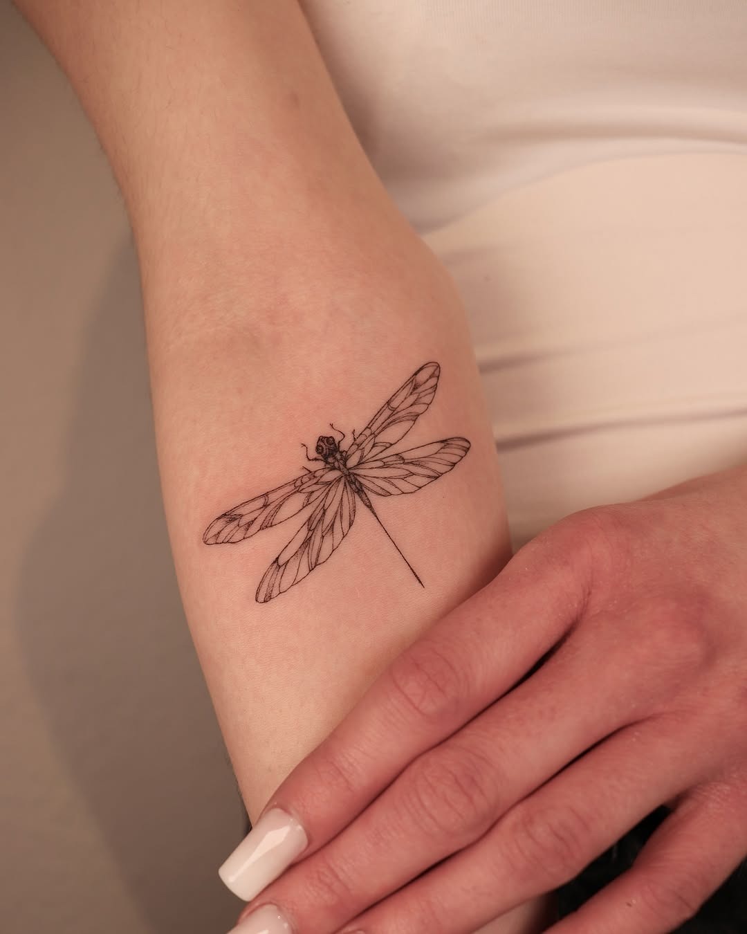 This tattoo showcases a delicate firefly, drawn with intricate line work.