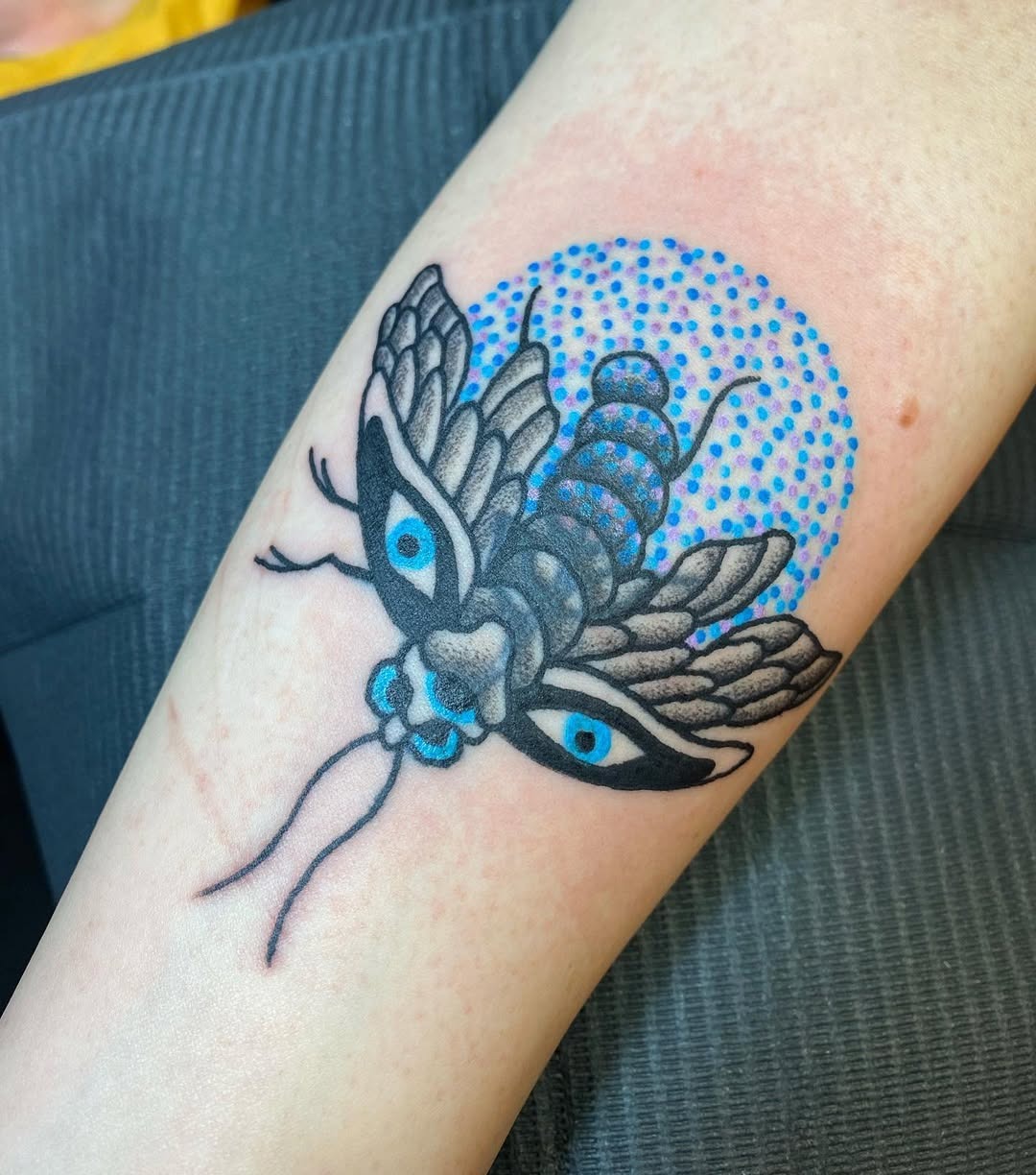 This striking firefly tattoo features a detailed design with bold black outlines and mesmerizing blue accents.