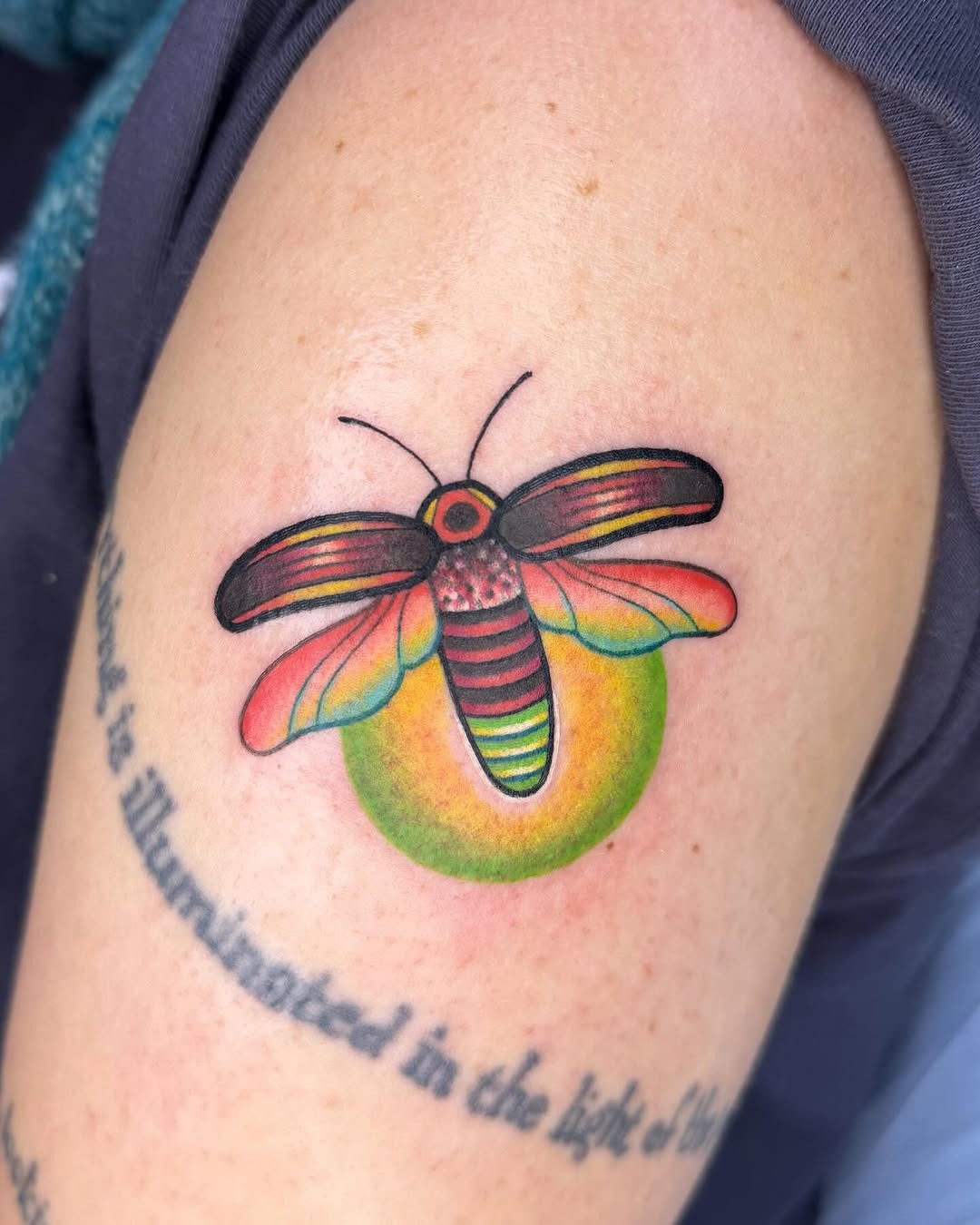 This firefly tattoo showcases a beautifully detailed design, featuring hues that bring it to life.