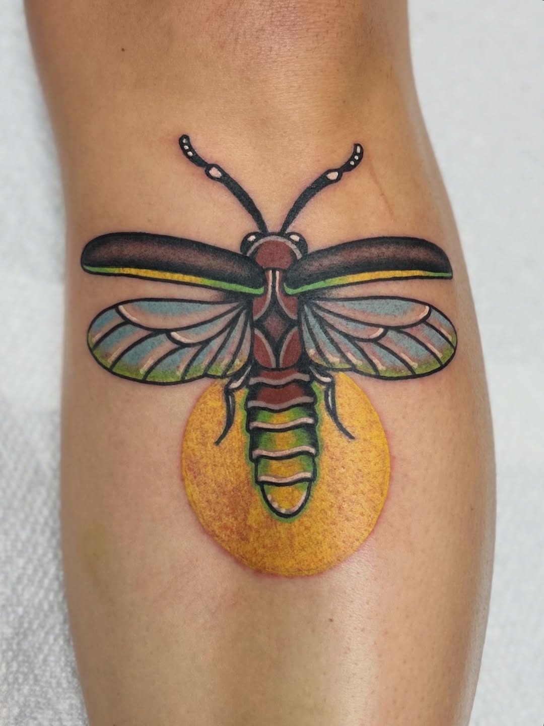 This firefly tattoo features bright colors and intricate details.