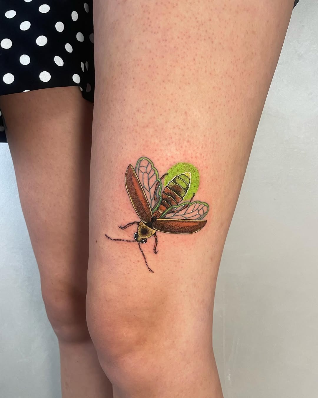 This firefly tattoo features intricate details and colors that bring it to life.