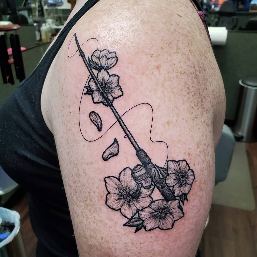 Feminine Floral Fishing Rod Tattoo, a tattoo design rendered in clean detailed linework for the leg.