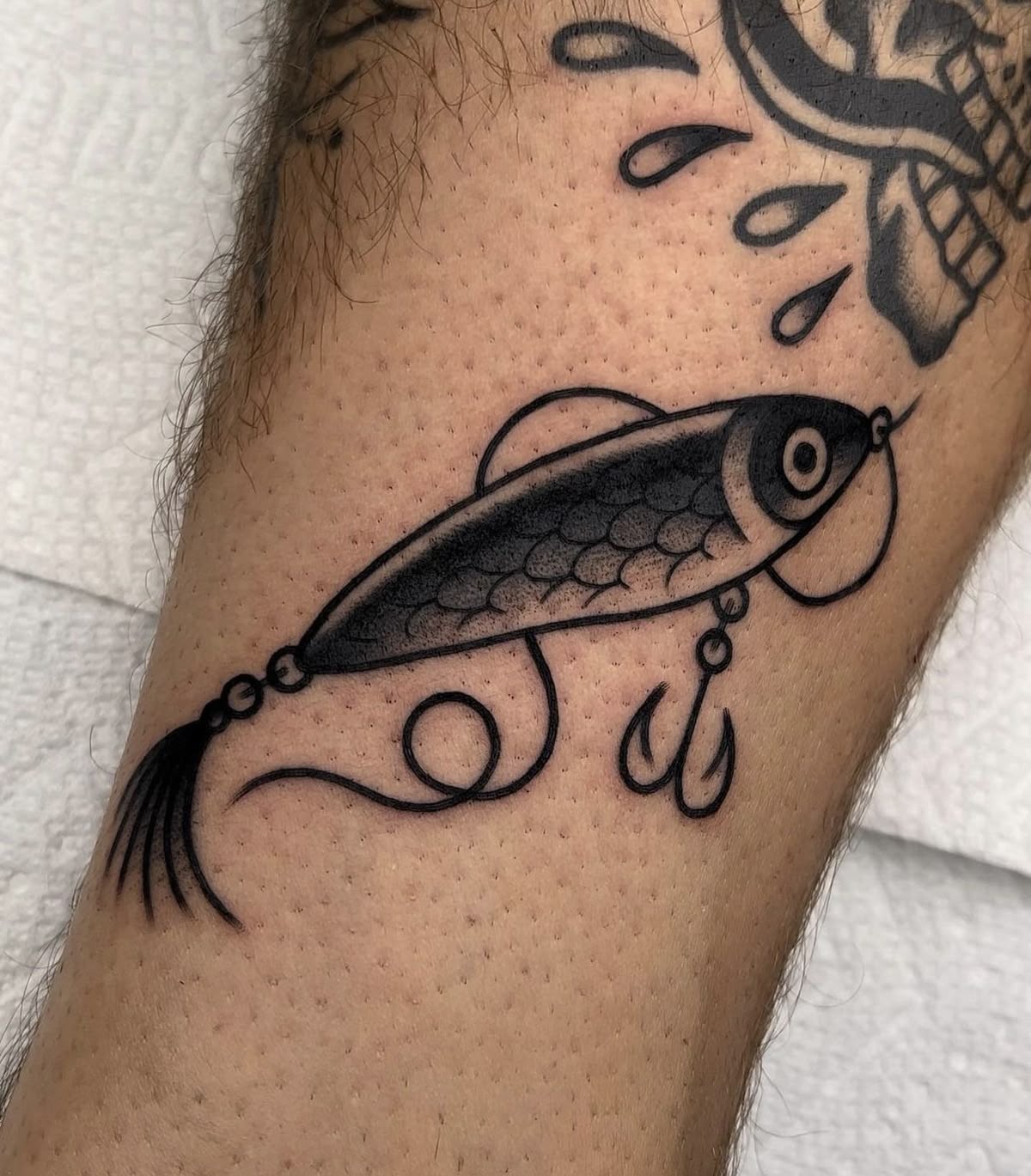Simple Fine Line Fishing Lure Tattoo, a tattoo design rendered in clean detailed linework for the leg.