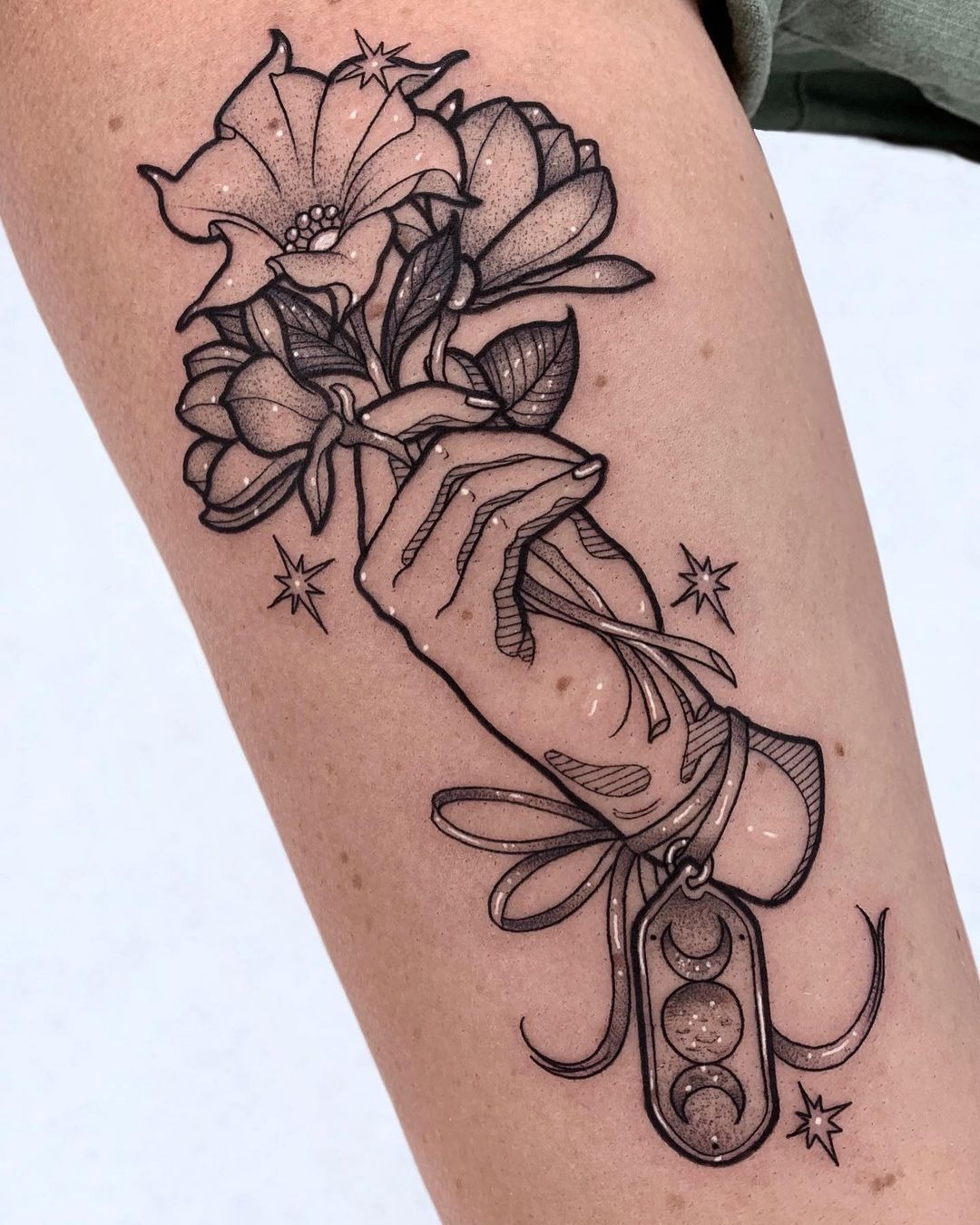 Hand-Held Bouquet With Moon Charm for a Little Magic, a tattoo design rendered in clean detailed linework.