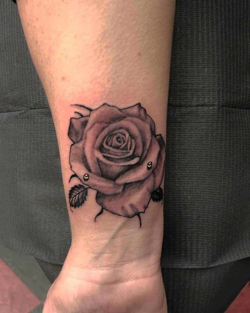 Shaded Rose Wrist Tattoo with Piercing Accents Tattoo Design