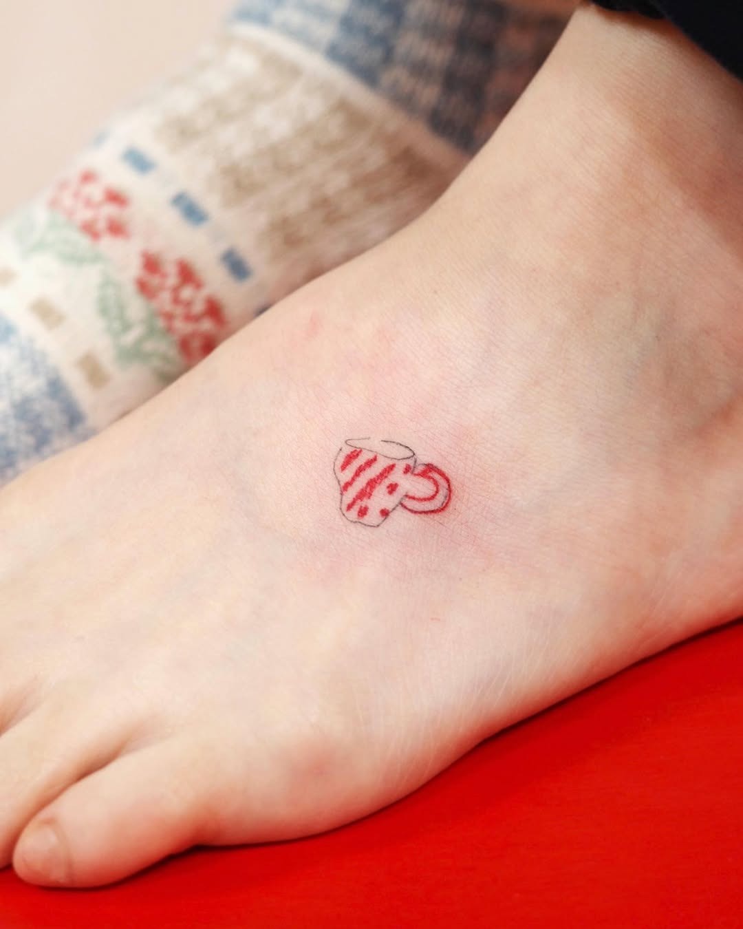 Charming red cup foot tattoo design Tattoo Design