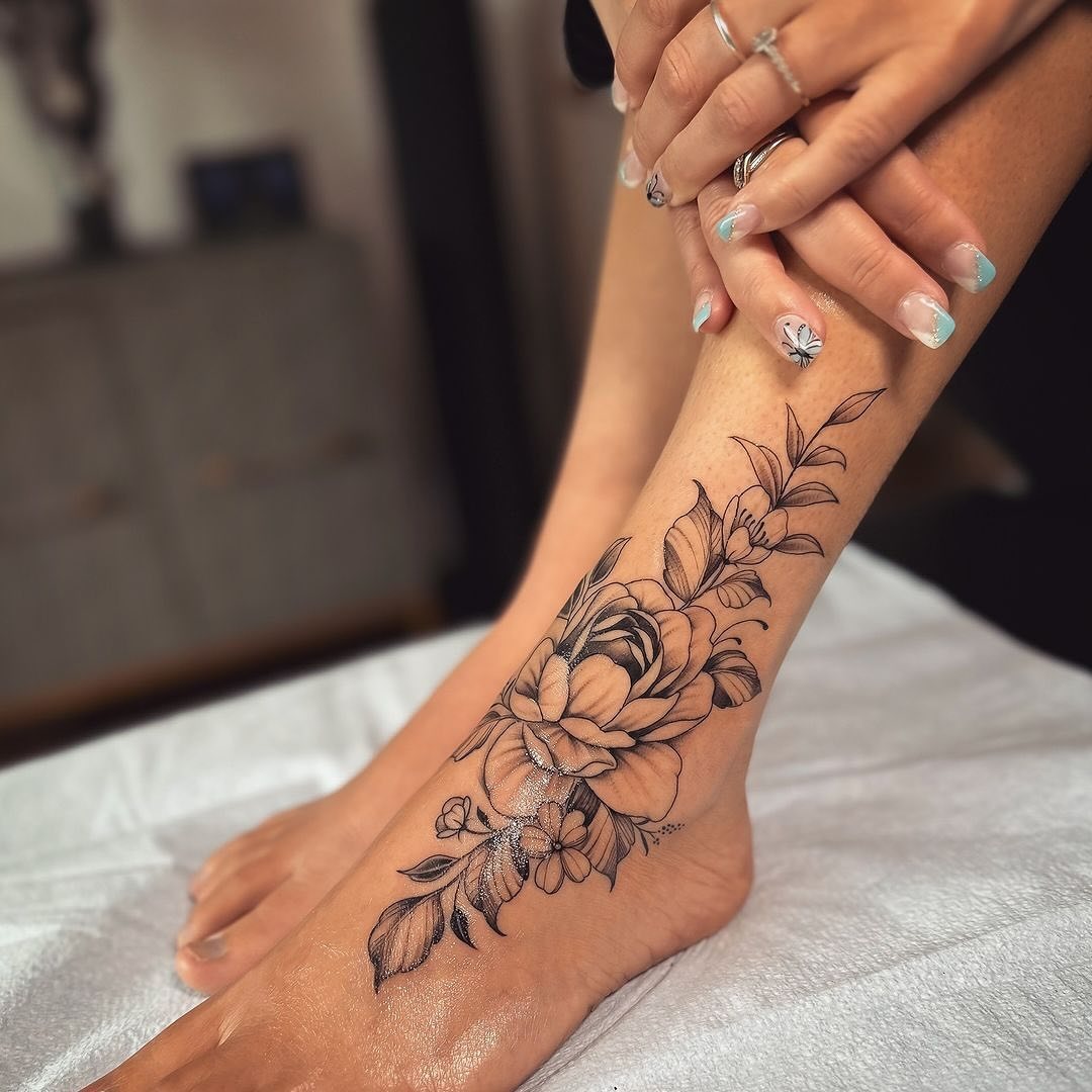 Elegant floral foot tattoo in black ink Tattoo Design
