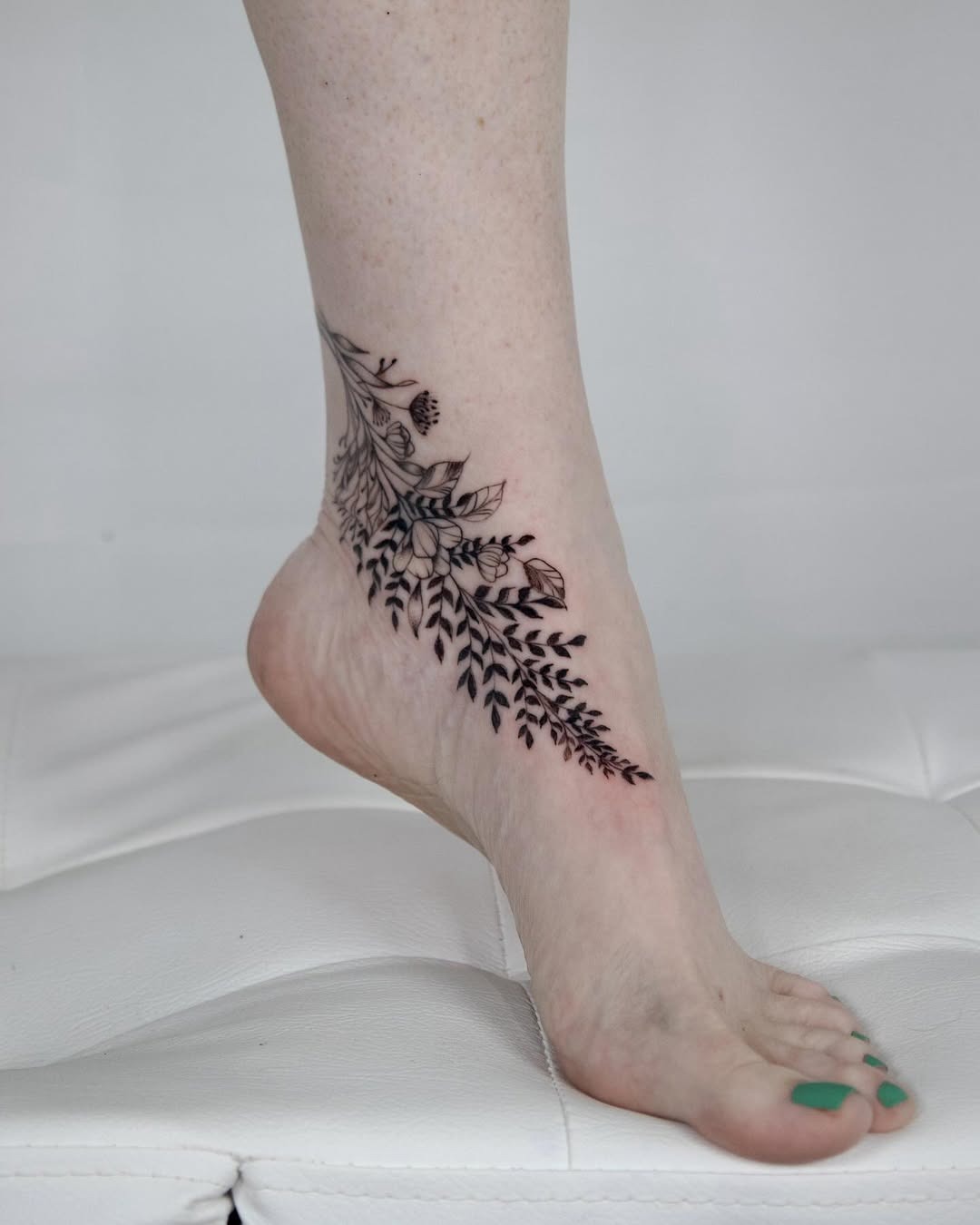Elegant floral foot tattoo wrapped around ankle Tattoo Design