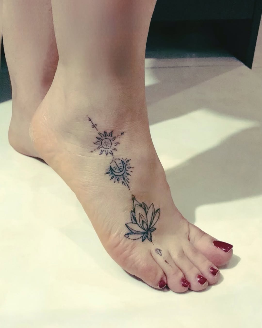 Intricate foot tattoo showcasing sun and lotus Tattoo Design