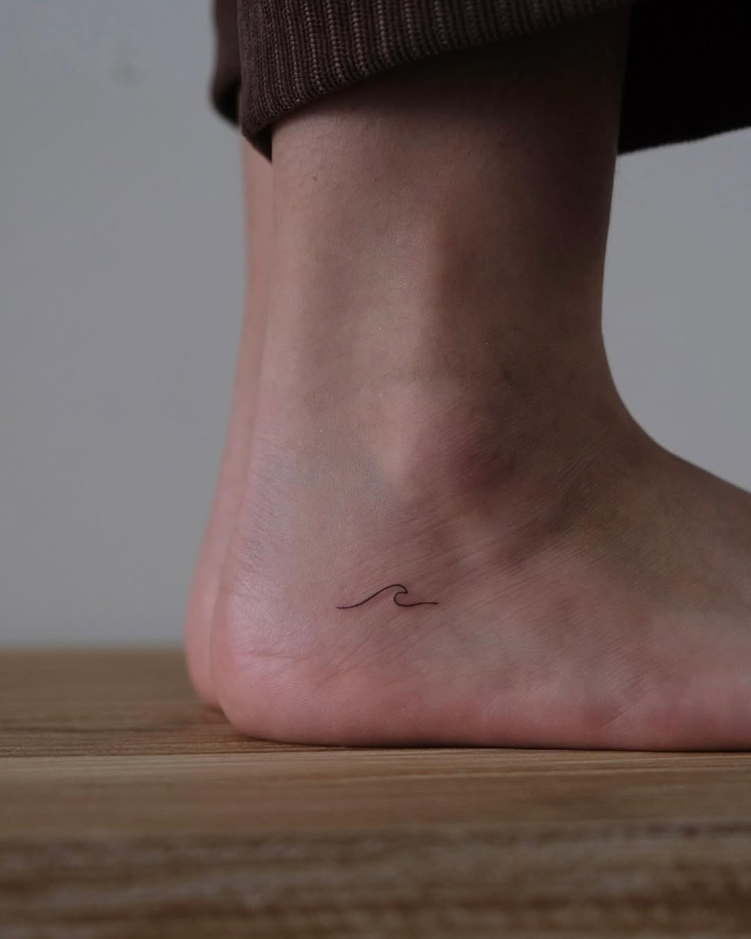 Minimalist wave tattoo on the ankle Tattoo Design