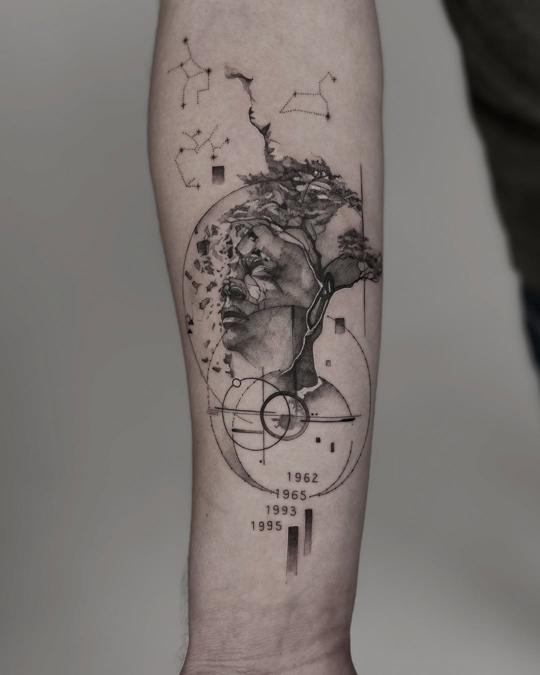 This forearm tattoo showcases a detailed black and gray design featuring an enigmatic figure with a majestic beard.