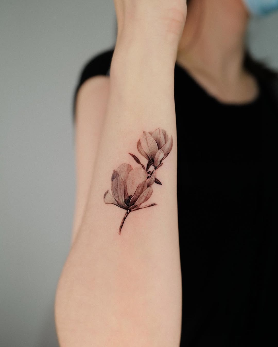 This forearm tattoo features elegant, detailed flowers, showing a minimalistic yet impactful design.