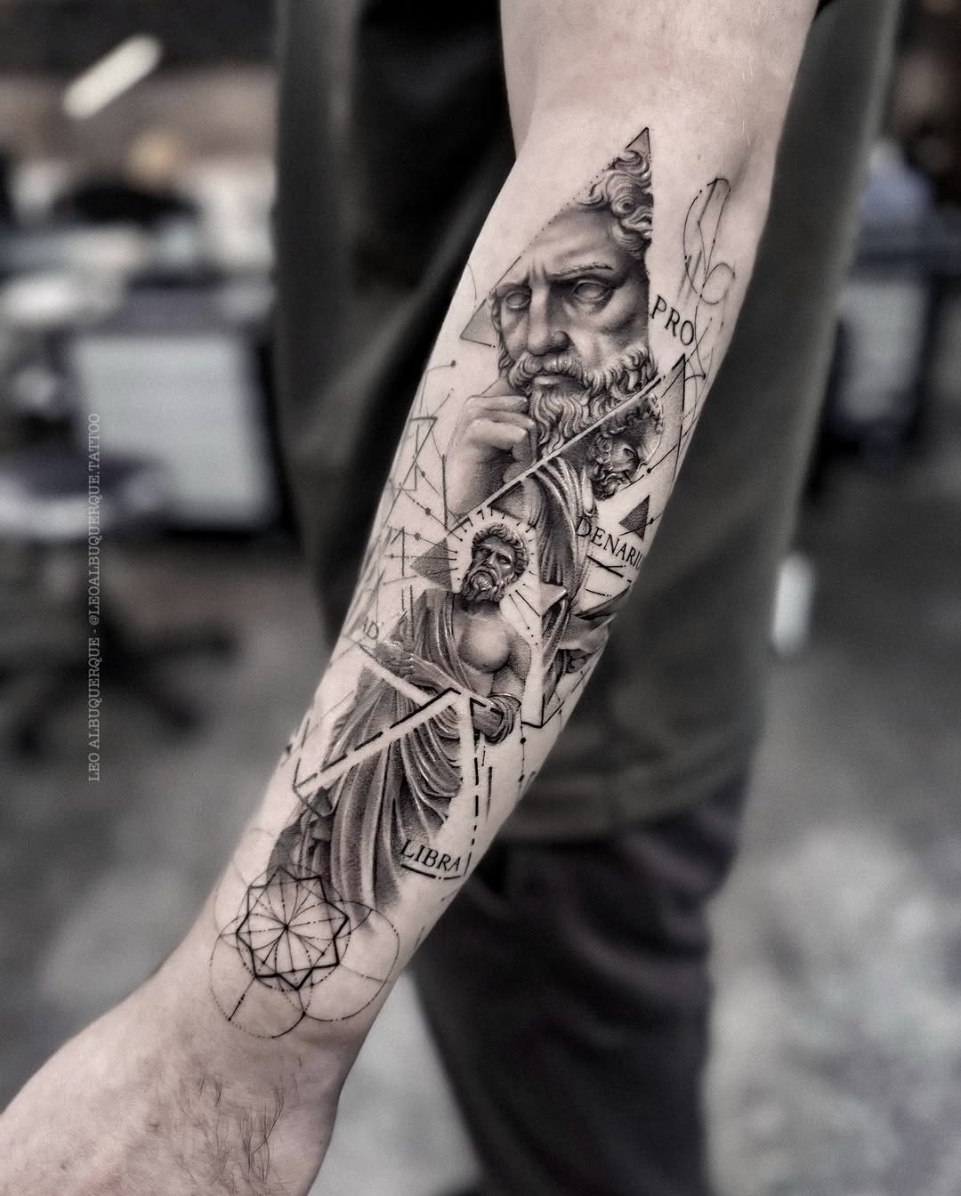 This forearm tattoo showcases a detailed black and gray design featuring an enigmatic figure with a majestic beard.