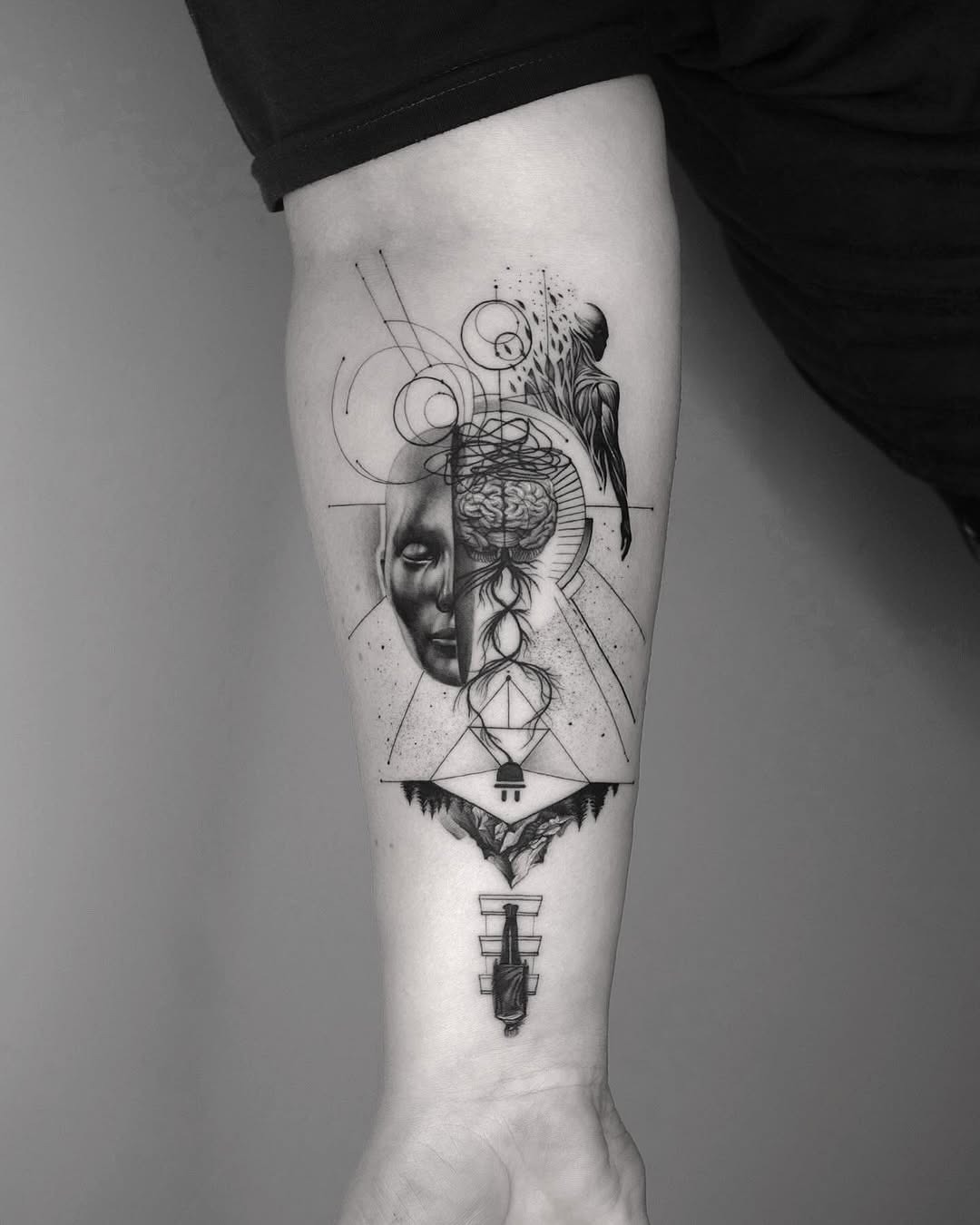 This forearm tattoo showcases a brilliant blend of geometry, abstract art, and human face imagery.