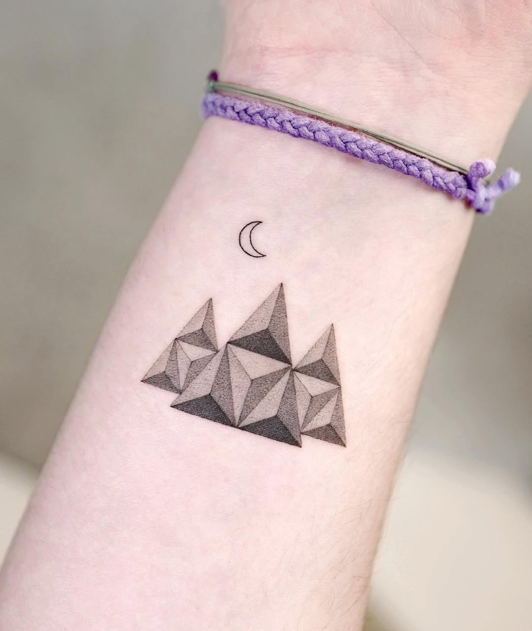 This forearm tattoo features stunning geometric mountains, skillfully shaded for depth and dimension.