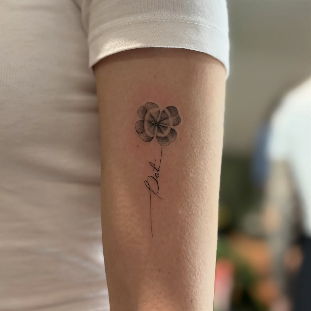 Intricate four leaf clover tattoo with elegant script Tattoo Design