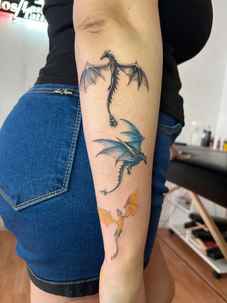 Three-Dragon Forearm Tattoo in Black, Blue, and Gold Tattoo Design