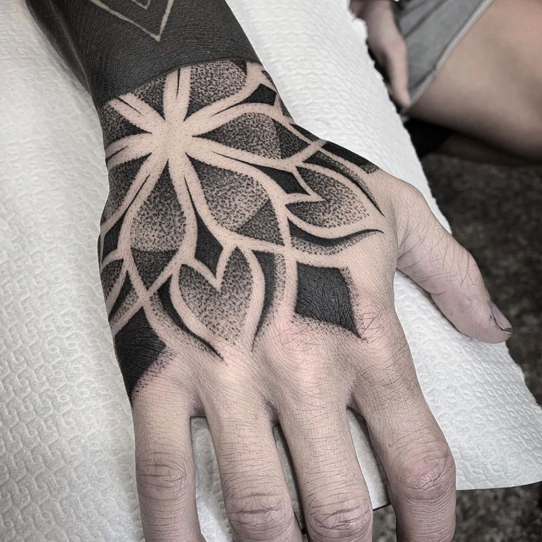 Black Geometric Hand Tattoo with Floral Negative Space Tattoo Design