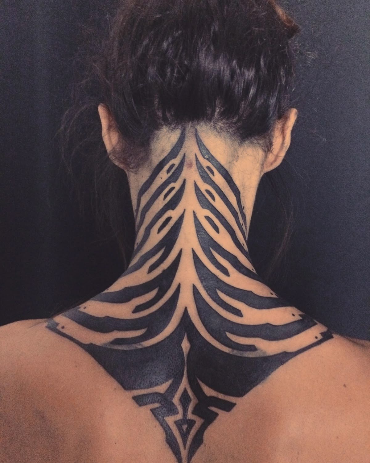 Bold Back-of-Neck Tribal Tattoo with Symmetrical Shape Tattoo Design