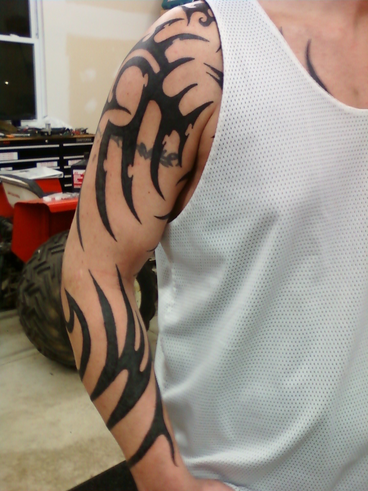 Bold Upper Arm Tribal Sleeve with Flame-Like Curves Tattoo Design