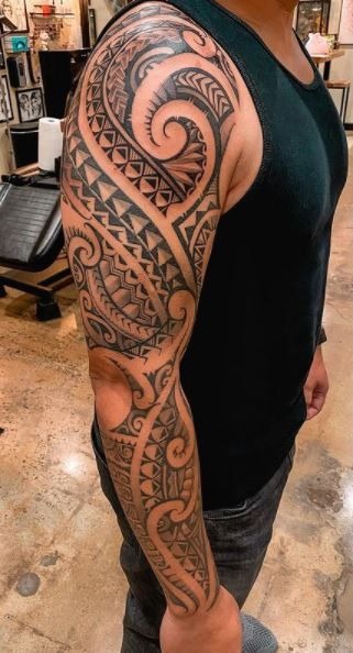 Full Arm Tribal Sleeve with Layered Cultural Motifs Tattoo Design