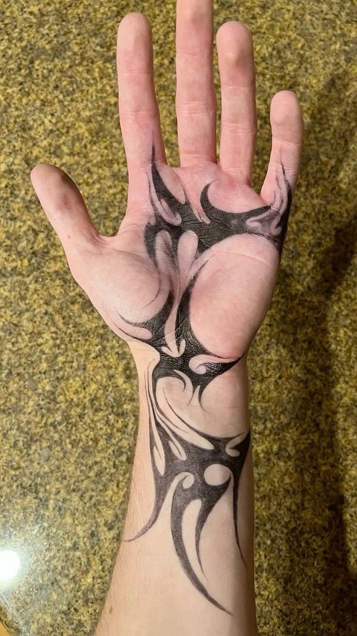 Palm and Wrist Tribal Tattoo with Dark Negative Space Tattoo Design