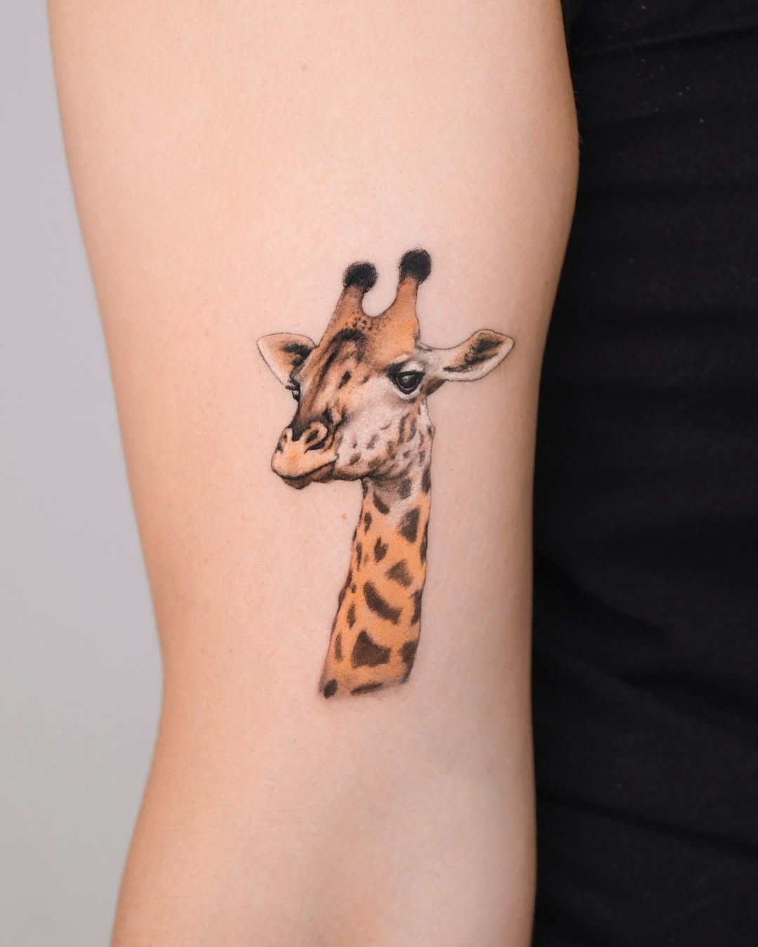 Charming giraffe head tattoo on an arm Tattoo Design