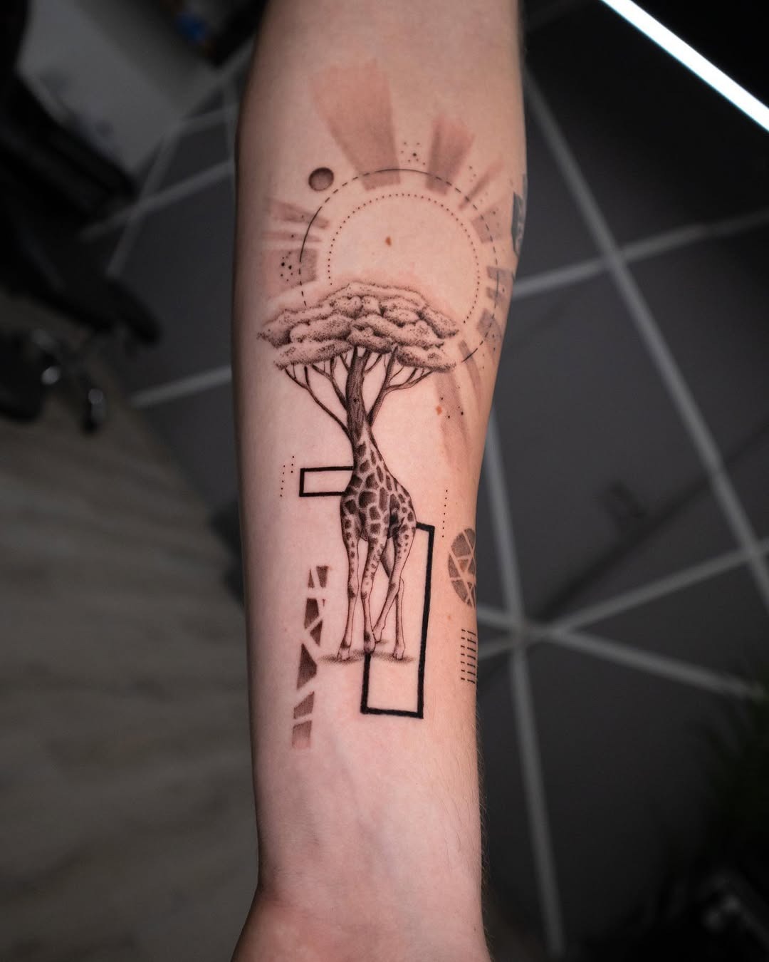 Elegant giraffe tattoo with tree elements Tattoo Design