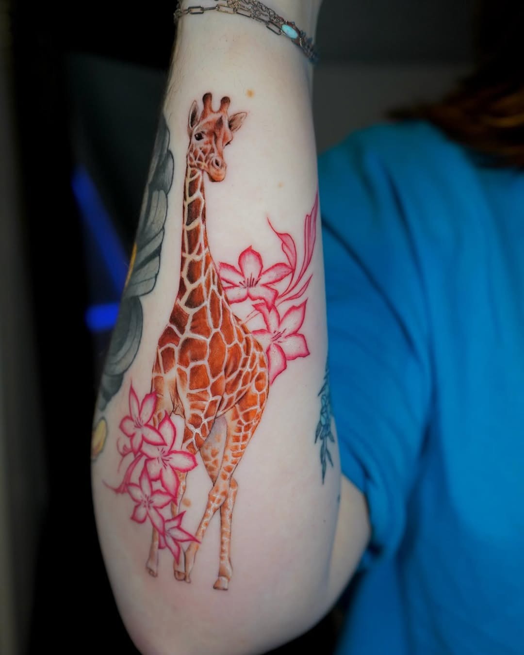 Vibrant giraffe surrounded by floral elements tattoo Tattoo Design